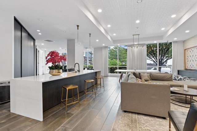 living area featuring floor to ceiling windows, recessed lighting, light wood-style floors, and a raised ceiling
