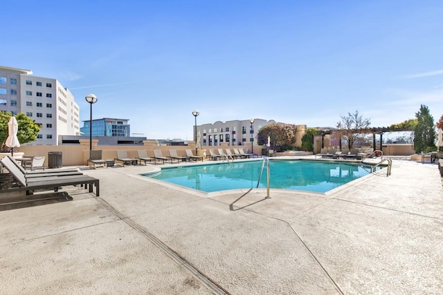 community pool with a patio area and a pergola