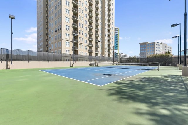 view of tennis court with fence and community basketball court