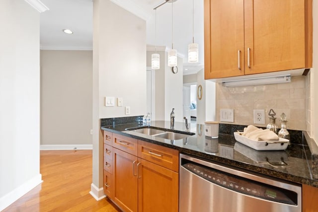 kitchen featuring stainless steel dishwasher, a sink, dark stone counters, ornamental molding, and decorative backsplash