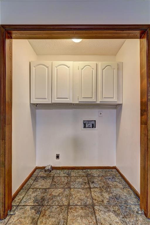washroom featuring baseboards, electric dryer hookup, cabinet space, and washer hookup