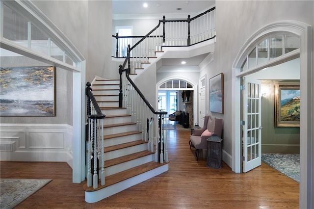 entryway featuring french doors, crown molding, and hardwood / wood-style flooring