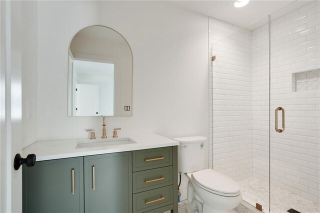 bathroom featuring vanity, toilet, and walk in shower