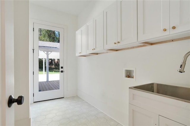 laundry room featuring cabinets, light tile patterned floors, sink, and hookup for a washing machine