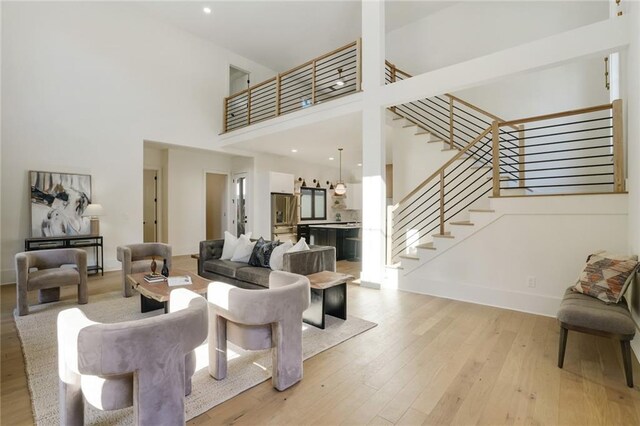 living room featuring a high ceiling and light wood-type flooring