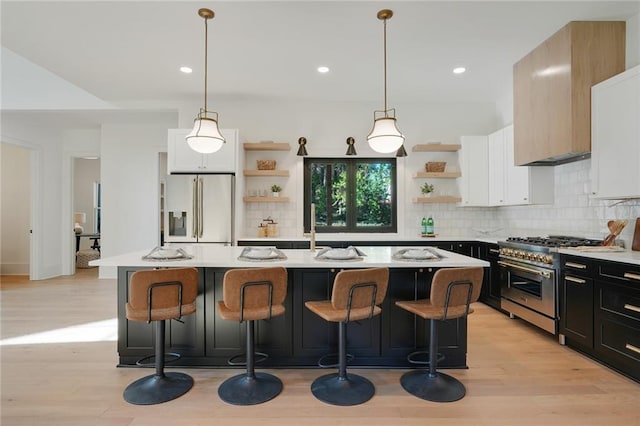 kitchen with pendant lighting, an island with sink, and appliances with stainless steel finishes