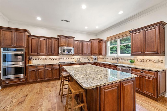 2317 Whiting Bay Cts NW, Kennesaw, GA 30152 - kitchen with stainless steel appliances, a kitchen bar, light wood-style floors, a center island, and light stone counters
