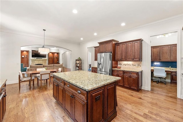 2317 Whiting Bay Cts NW, Kennesaw, GA 30152 - kitchen featuring stainless steel fridge with ice dispenser, arched walkways, backsplash, built in study area, and a kitchen island
