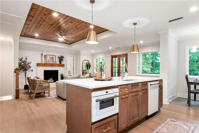 455 Sams Rd, Dawsonville, GA 30534 - kitchen featuring a sink, white appliances, light countertops, light wood-type flooring, and hanging light fixtures