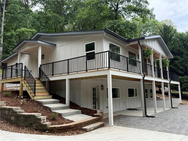 455 Sams Rd, Dawsonville, GA 30534 - view of front facade featuring board and batten siding, stairway, view of wooded area, and a patio