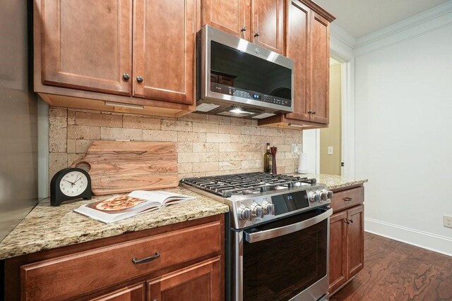 23 Durana Ct, Dallas, GA 30132 - kitchen featuring stainless steel appliances, crown molding, light stone counters, backsplash, and dark wood finished floors