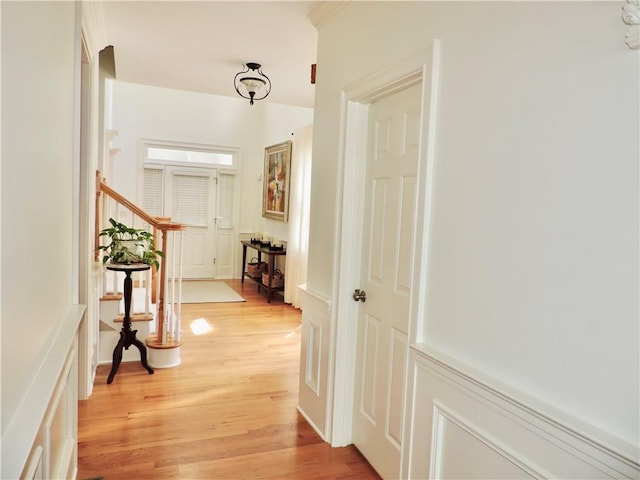 hallway featuring a decorative wall and light wood-style flooring