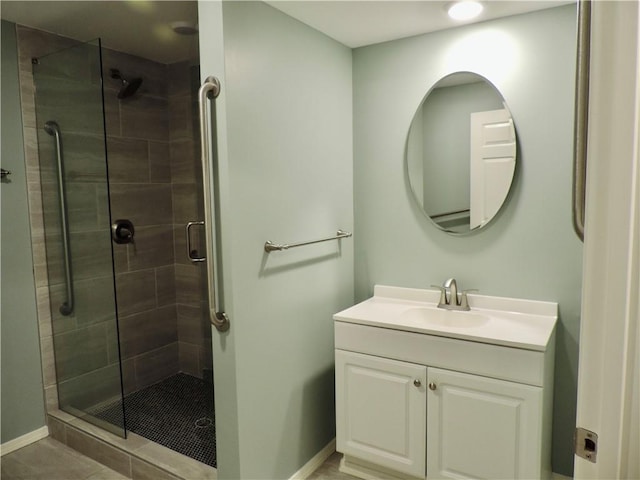 full bath with a stall shower, baseboards, tile patterned floors, and vanity
