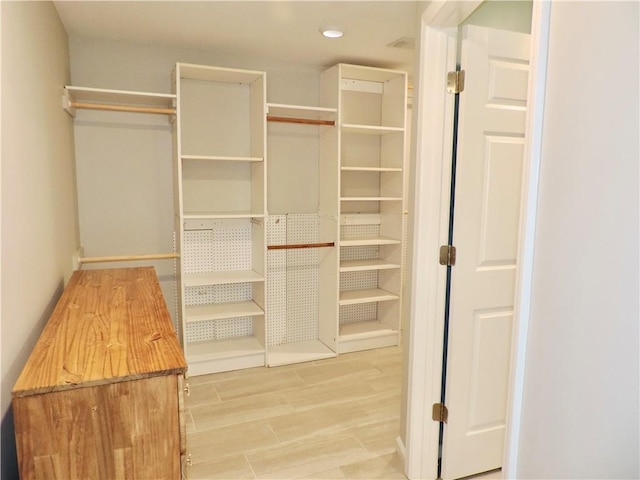 walk in closet with wood finished floors