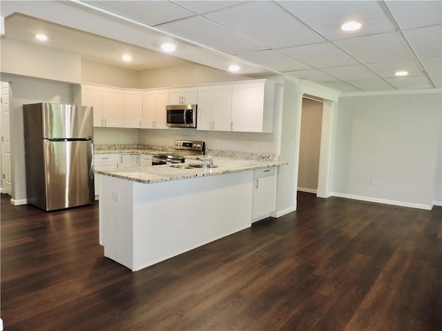 kitchen featuring a peninsula, recessed lighting, white cabinetry, light stone countertops, and appliances with stainless steel finishes