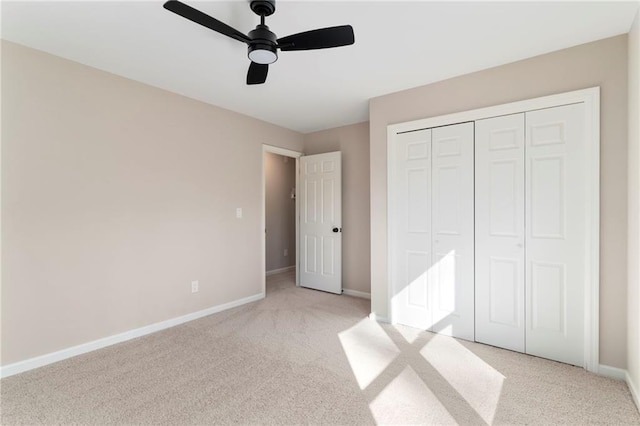 unfurnished bedroom featuring light carpet, ceiling fan, and a closet