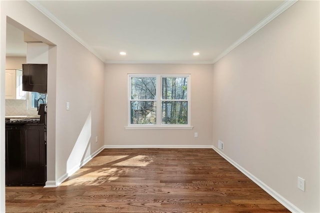 empty room with crown molding, dark hardwood / wood-style flooring, and a wealth of natural light