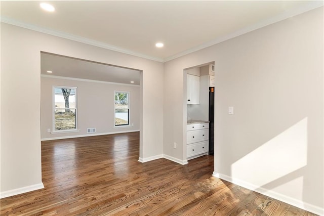 empty room with ornamental molding and dark hardwood / wood-style floors