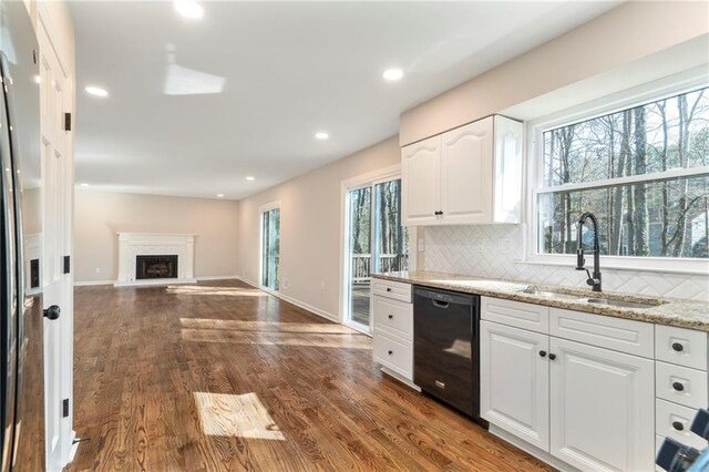 kitchen featuring white cabinetry, dishwasher, sink, and light stone counters