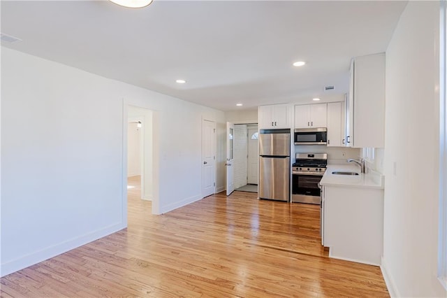 kitchen with white cabinetry, sink, light hardwood / wood-style flooring, and stainless steel appliances