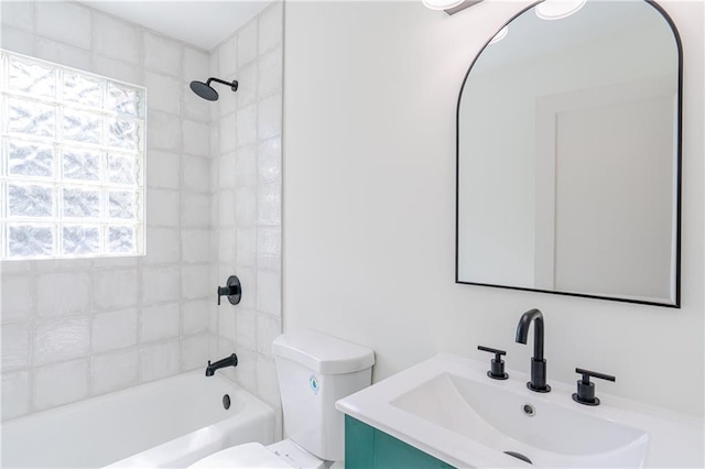 full bathroom featuring tiled shower / bath, vanity, and toilet