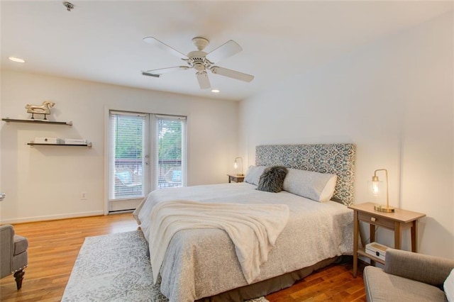 bedroom with access to exterior, hardwood / wood-style flooring, and ceiling fan