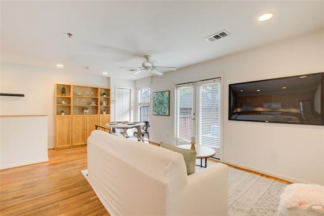 living room featuring ceiling fan, french doors, and light wood-type flooring