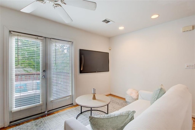 living room with ceiling fan, light hardwood / wood-style floors, and french doors