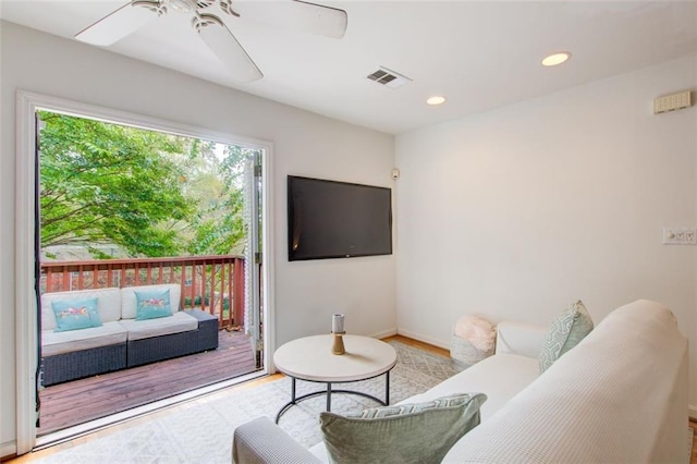 living room with light hardwood / wood-style floors and ceiling fan