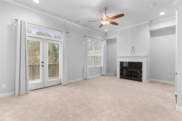 unfurnished living room featuring ceiling fan, light colored carpet, ornamental molding, and french doors