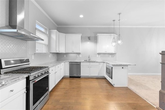 kitchen with white cabinetry, hanging light fixtures, kitchen peninsula, stainless steel appliances, and wall chimney range hood