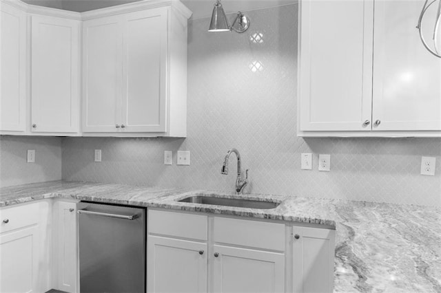 kitchen with tasteful backsplash, white cabinetry, dishwasher, and sink