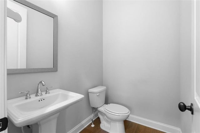 bathroom with sink, hardwood / wood-style flooring, and toilet