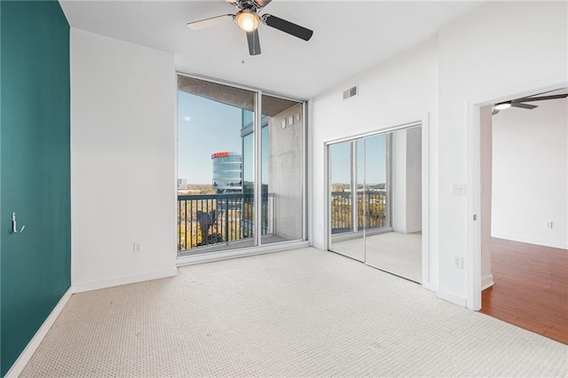 empty room featuring ceiling fan and carpet