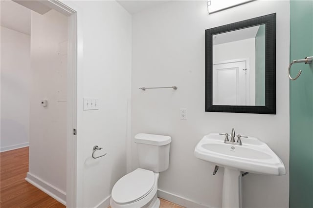 bathroom featuring hardwood / wood-style flooring and toilet