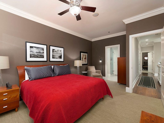 bedroom with carpet floors, a ceiling fan, baseboards, ornamental molding, and ensuite bath