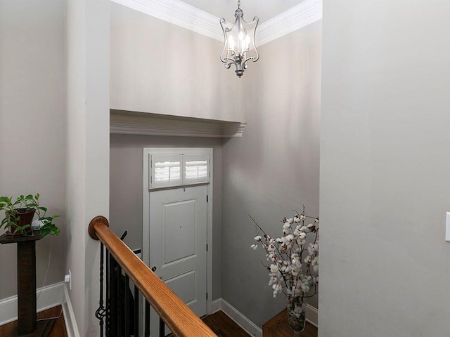 entryway with crown molding, baseboards, and a notable chandelier