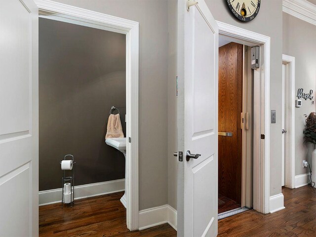 hallway featuring wood finished floors and baseboards