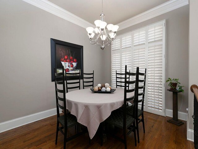 dining area featuring baseboards, ornamental molding, a chandelier, and wood finished floors