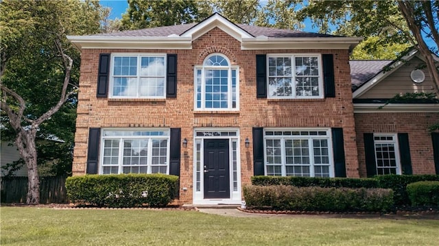 view of front of house with brick siding and a front lawn
