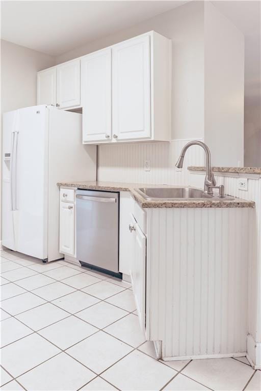 kitchen with dishwasher, a sink, white cabinetry, light stone countertops, and white fridge with ice dispenser