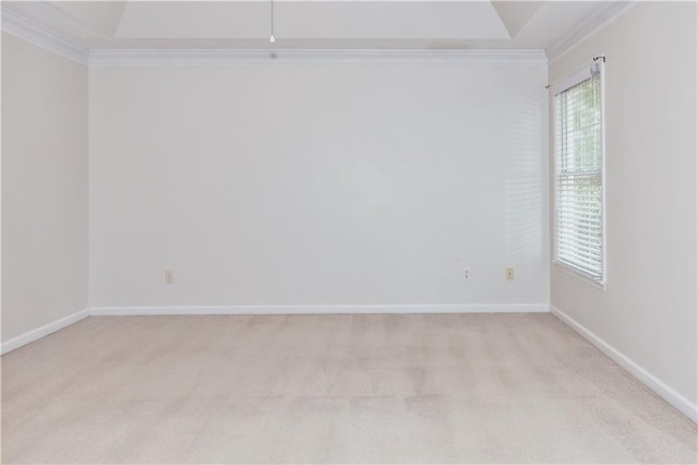 empty room with ornamental molding, light colored carpet, and baseboards