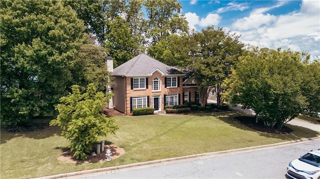 colonial house with a chimney and a front yard
