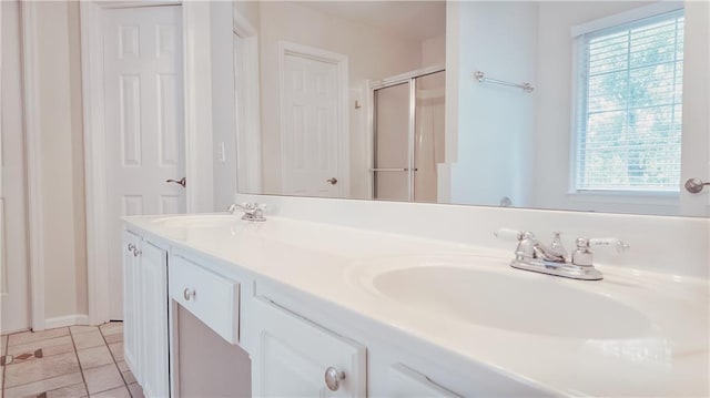 bathroom with plenty of natural light, a shower stall, double vanity, and tile patterned flooring