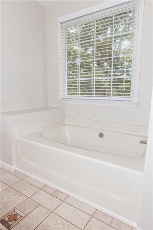 full bath with a garden tub, healthy amount of natural light, and tile patterned floors
