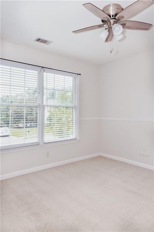 spare room with light carpet, baseboards, and a ceiling fan
