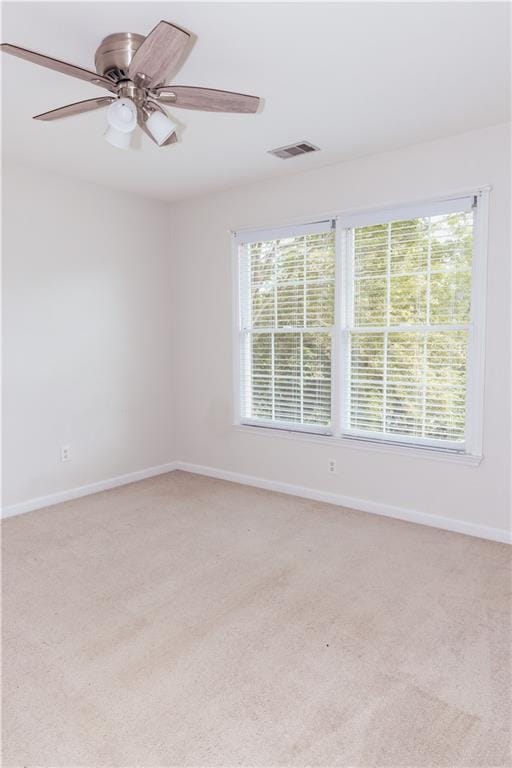 empty room featuring light carpet, baseboards, and ceiling fan