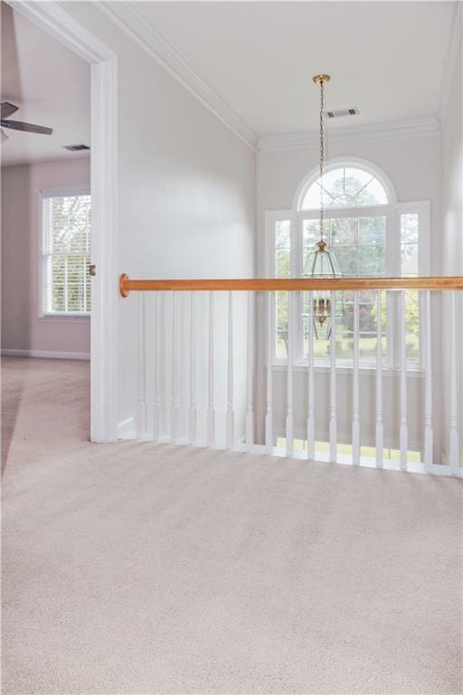 corridor with carpet, a chandelier, and crown molding