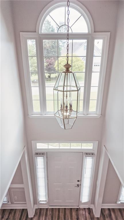 entryway featuring a chandelier, dark wood-style flooring, and a high ceiling