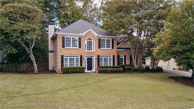 colonial-style house with a chimney and brick siding